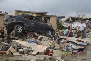 Image: Residents stand outside their damaged house after a tornado hit the town of Ciudad Acuna