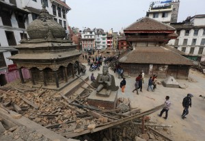 People walk past the rubble of a temple destroyed in Saturday's earthquake, in Kathmandu
