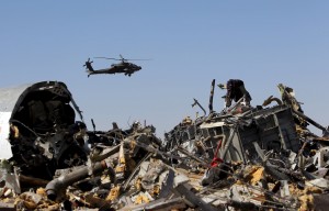 An Egyptian military helicopter flies over debris from a Russian airliner which crashed at the Hassana area in Arish city, north Egypt, November 1, 2015. Russia has grounded Airbus A321 jets flown by the Kogalymavia airline, Interfax news agency reported on Sunday, after one of its fleet crashed in Egypt's Sinai Peninsula, killing all 224 people on board. REUTERS/Mohamed Abd El Ghany