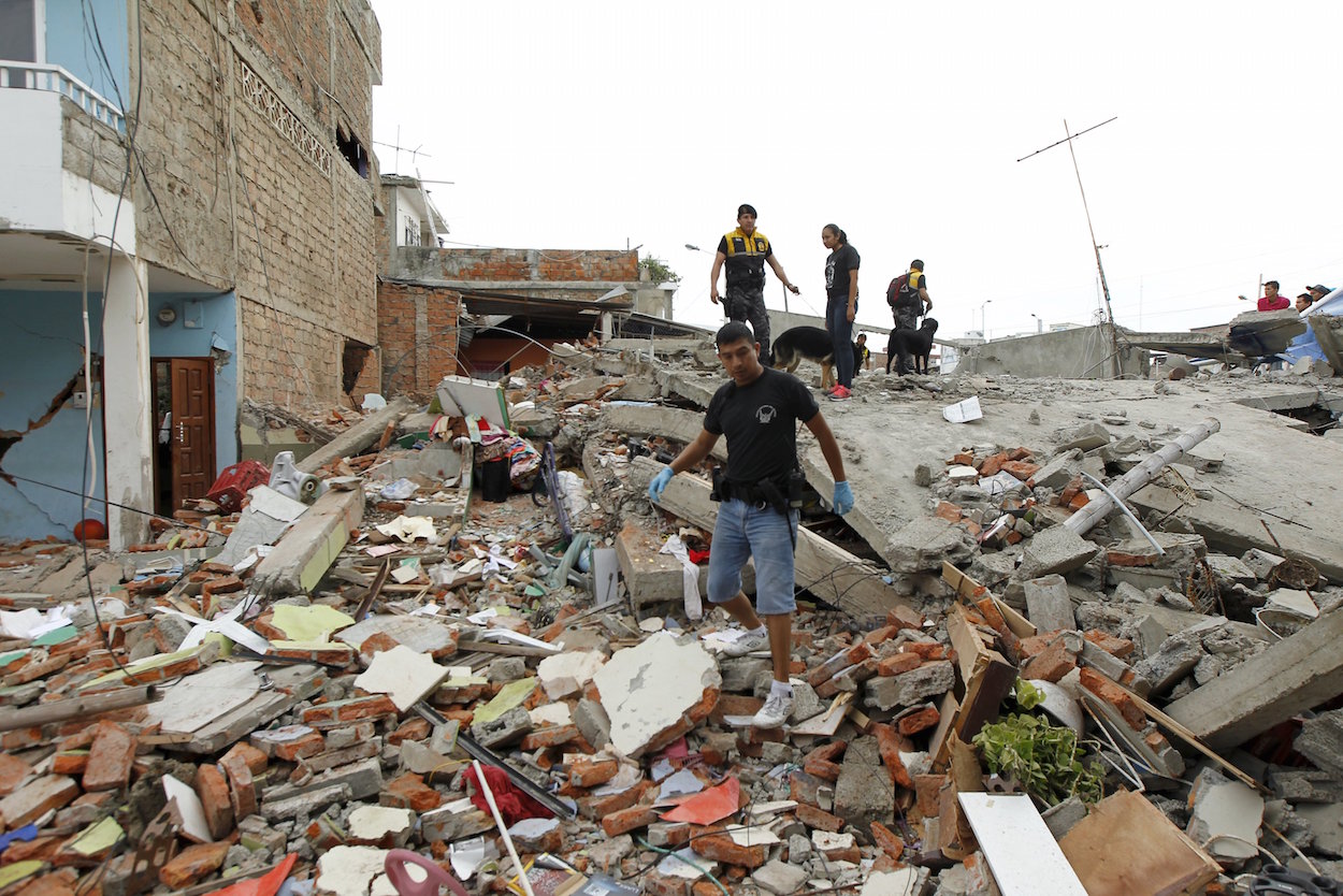 Red Cross members, military and police officers work at a collapsed area after an earthquake struck off the Pacific coast, at Tarqui neighborhood in Manta, Ecuador April 17, 2016.  REUTERS/Guillermo Granja