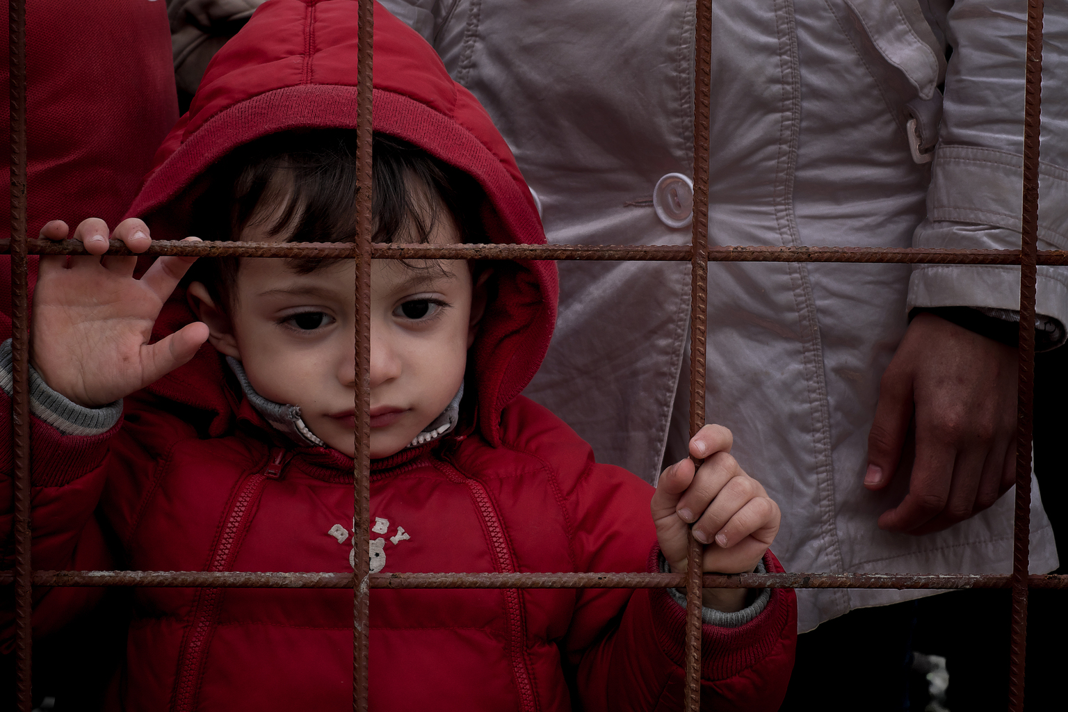 On 26 November, a small child stands with adults at a wire fence in the town of Gevgelija, on the border with Greece. In the former Yugoslav Republic of Macedonia, the Government has begun restricting the flow of refugees and migrants on the move, and is allowing only Syrians, Iraqis and Afghans to continue their journey. About 1,000 people are stranded at the main entry point into the former Yugoslav Republic of Macedonia from Greece. In late November 2015, refugee and migrant flows into Europe remain at an unprecedented high. Since the beginning of the year, over 870,000 refugees and migrants have crossed the Mediterranean Sea to Europe. Many of them are escaping conflict and insecurity in their home countries of Afghanistan, Iraq, Pakistan and the Syrian Arab Republic. More than one in five is a child.  Recent restrictions imposed by governments at several border crossings in the Balkans is creating additional hardships and challenges for refugee and migrants, including leaving some stranded at various crossing points, creating tensions and protests at border crossings, or forcing others to take further risks by taking dangerous smuggling routes to reach safety. UNICEF, together with partners UNHCR and IOM, is supporting child-friendly spaces in reception centres at border crossings along the Balkan routes, mobilizing for winter and working with governments to strengthen child protection systems for all children, including refugee and migrant children. UNICEF is also monitoring and providing assistance with partners at these points, and is providing blankets, winter clothing and other key items to meet basic needs. In late November 2015, refugee and migrant flows into Europe remain at an unprecedented high. Since the beginning of the year, over 870,000 refugees and migrants have crossed the Mediterranean Sea to Europe. Many of them are escaping conflict and insecurity in their home countries of Afghanistan, Iraq, Pakistan and the Syrian Arab Republic. More th